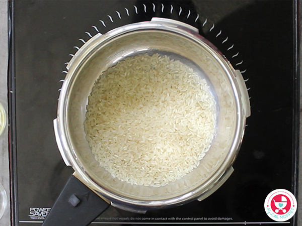 Add rice in pressure cooker.
