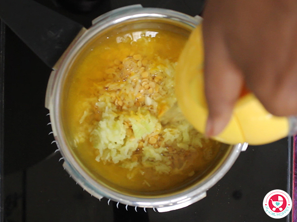 In a cooker, add grated mangoes, toordal, turmeric and salt.